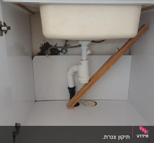 כיור עם צנרת מתחת לארון מטבח